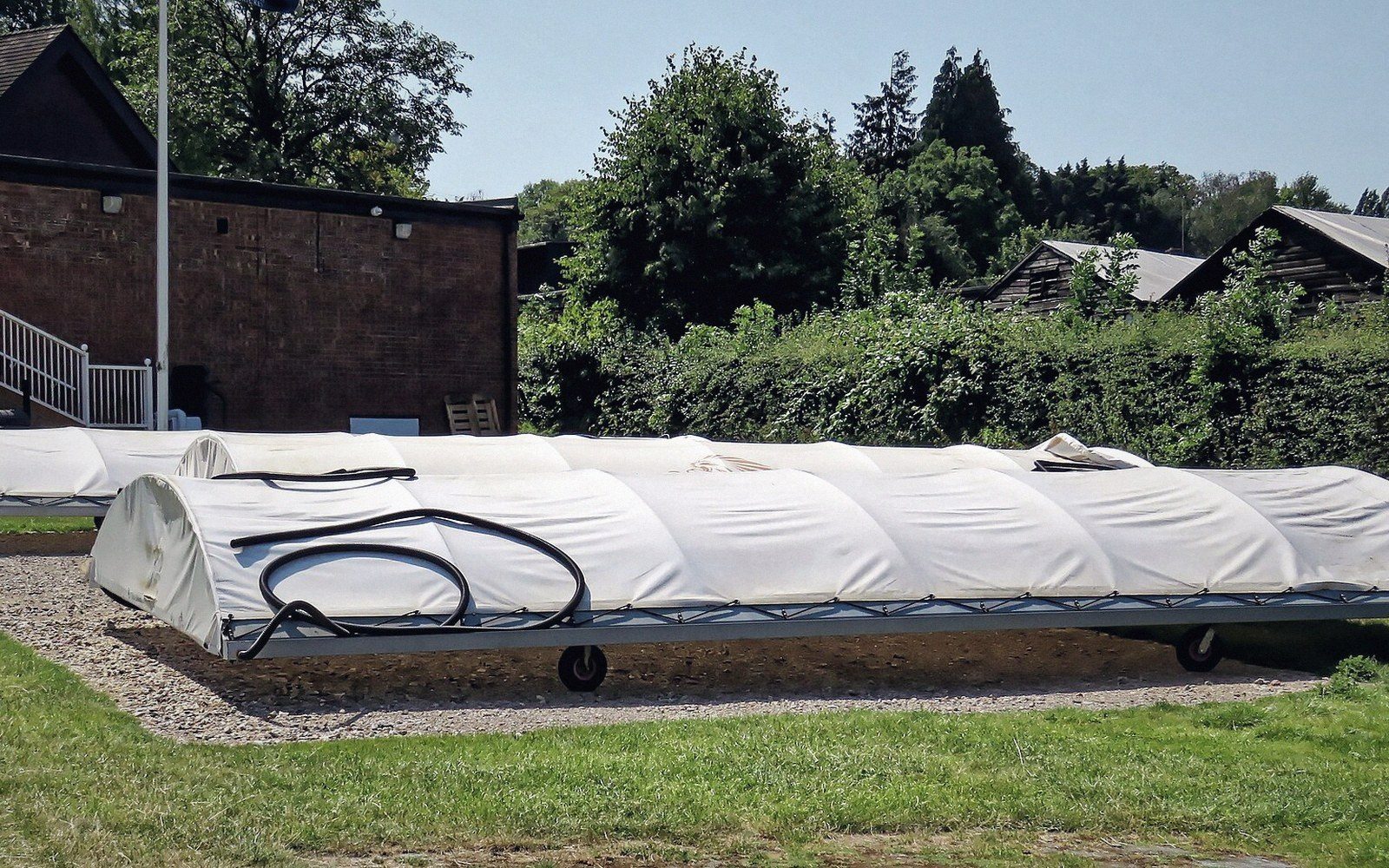 Covered roller pitch cricket net on a wheeled mobile frame outdoors