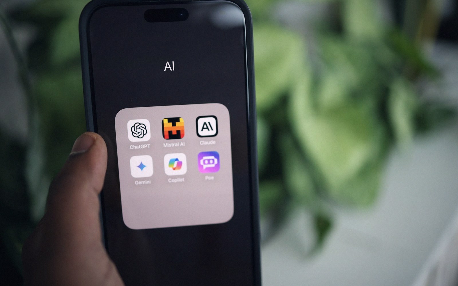 A smartphone screen showing an AI folder with ChatGPT, Mistral AI, Claude, Gemini, Copilot, and Poe icons