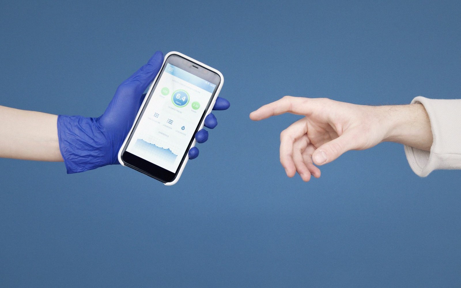 Gloved hand holding a smartphone with a health app reaches toward a bare outstretched hand